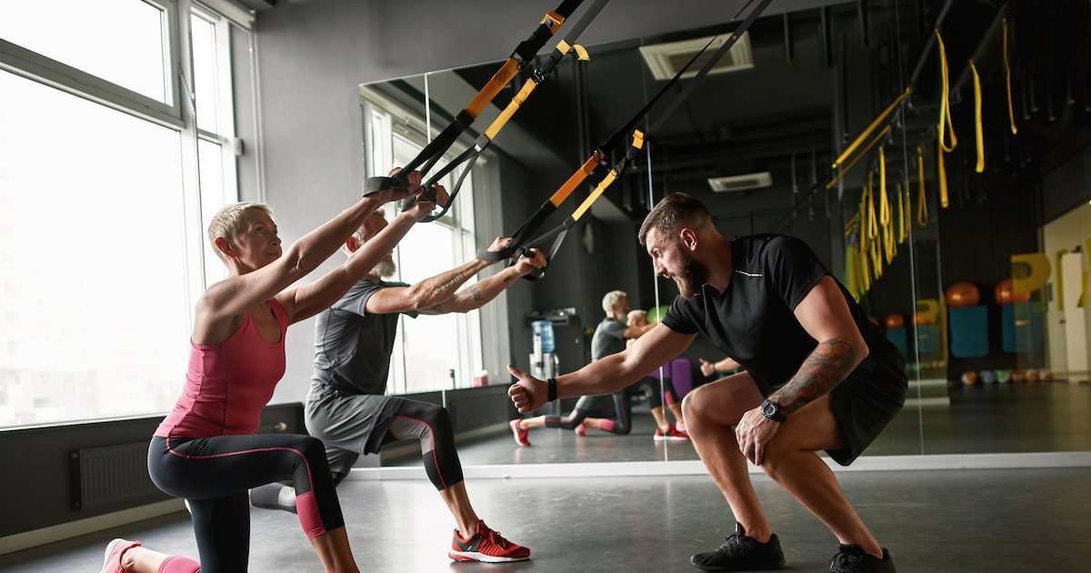 Idosos praticando Crossfit com orientação profissional em ambiente seguro